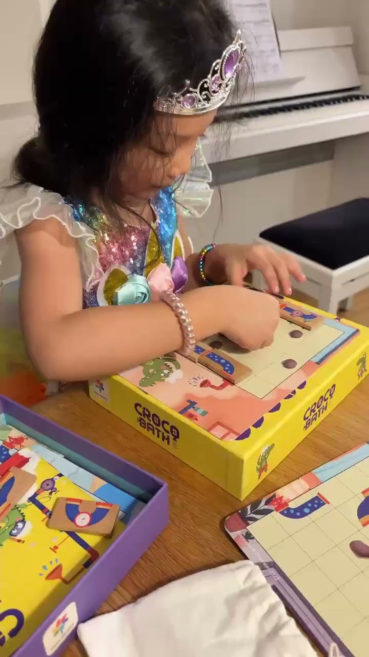Une petite fille concentrée sur une partie de Croco Bath